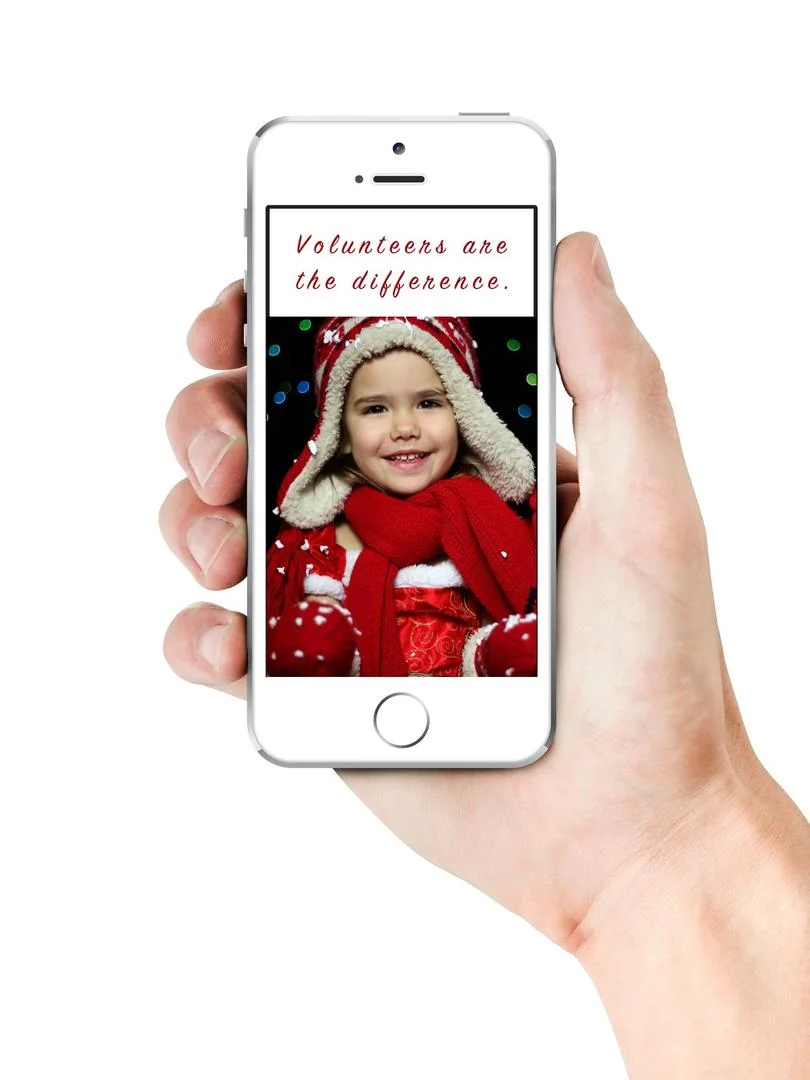 Volunteers are the difference: a child dressed for Christmas on a phone screen.